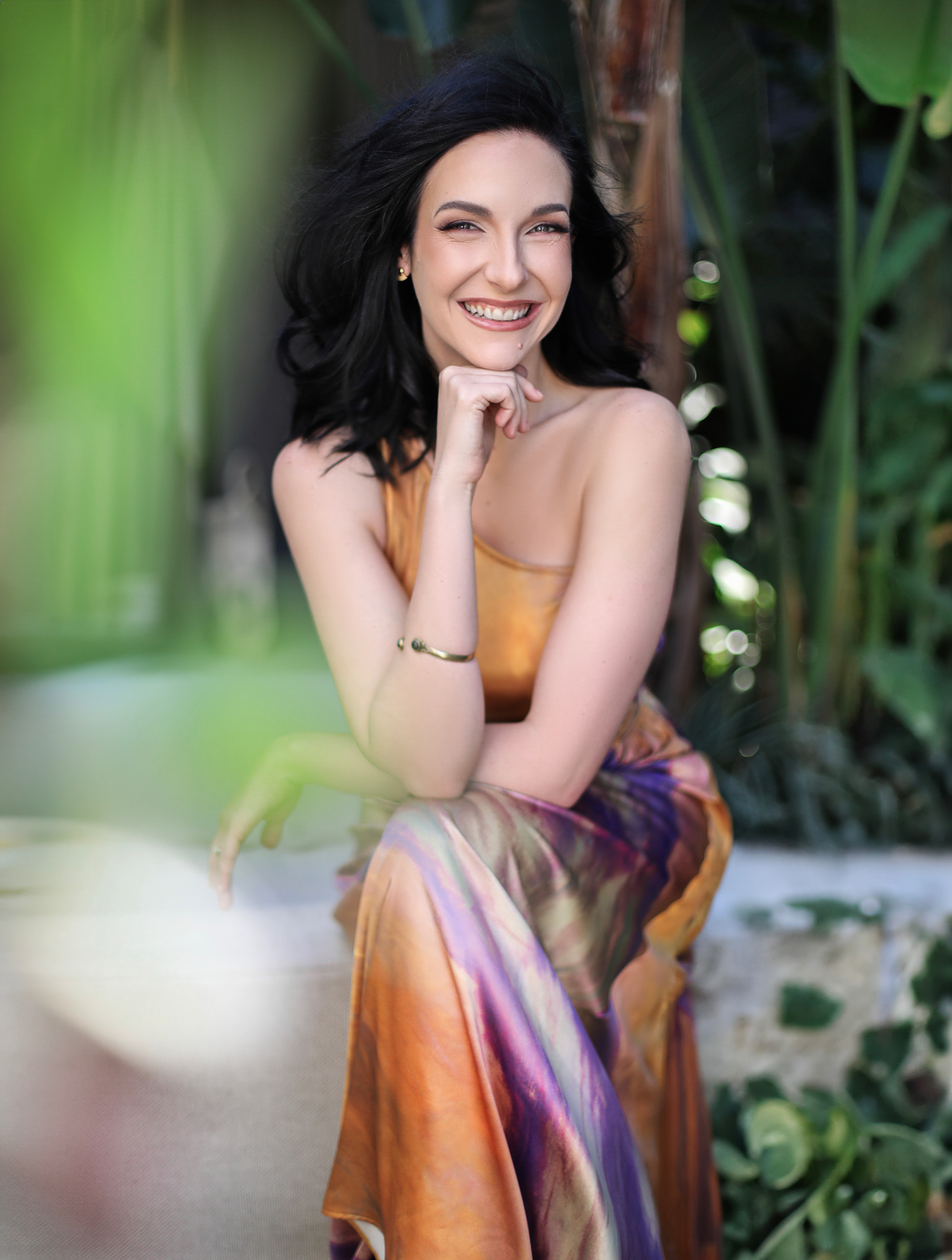 A garden lifestyle portrait of Melinda in a silk dress